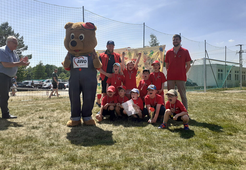 Gruppe von Personen bei einem Outdoor-Event mit einem Maskottchen