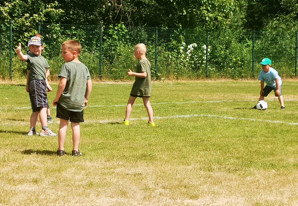 Kinder spielen Fu&szlig;ball im Freien
