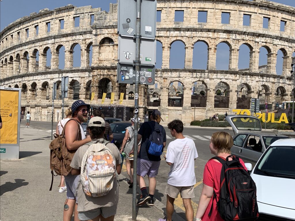 Gruppe von Menschen vor einem alten Amphitheater in Pula, Kroatien