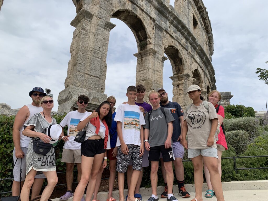 Gruppe von Menschen vor einem antiken Bauwerk
