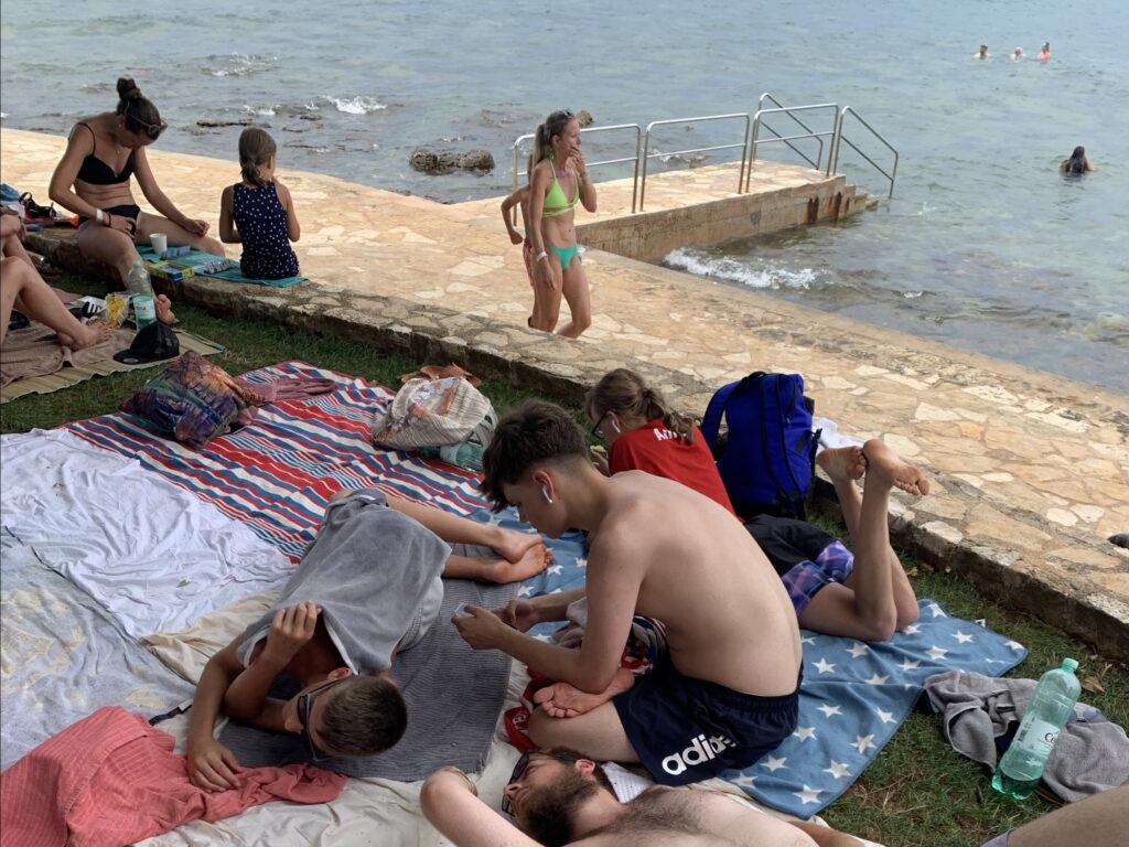 Menschen entspannen auf einer Wiese nahe am Meer