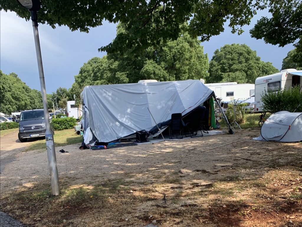 Campingplatzszene mit Zelt und Wohnmobilen