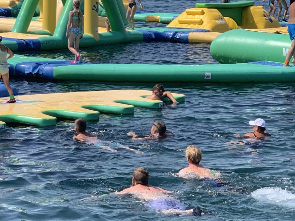Menschen im Wasser an einem aufblasbaren Wasserpark.