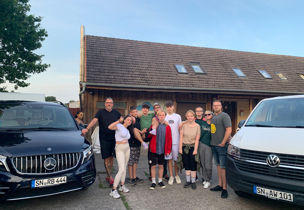 Eine Gruppe von Menschen steht vor einem Geb&auml;ude.