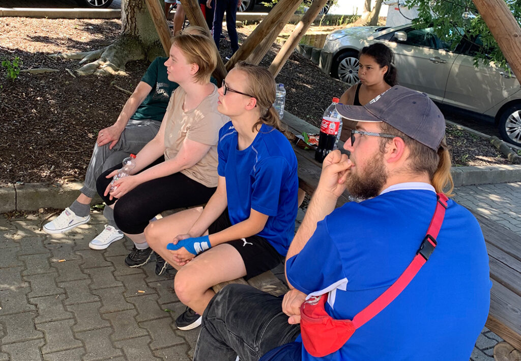 Gruppe von Menschen unter einer Holz&uuml;berdachung