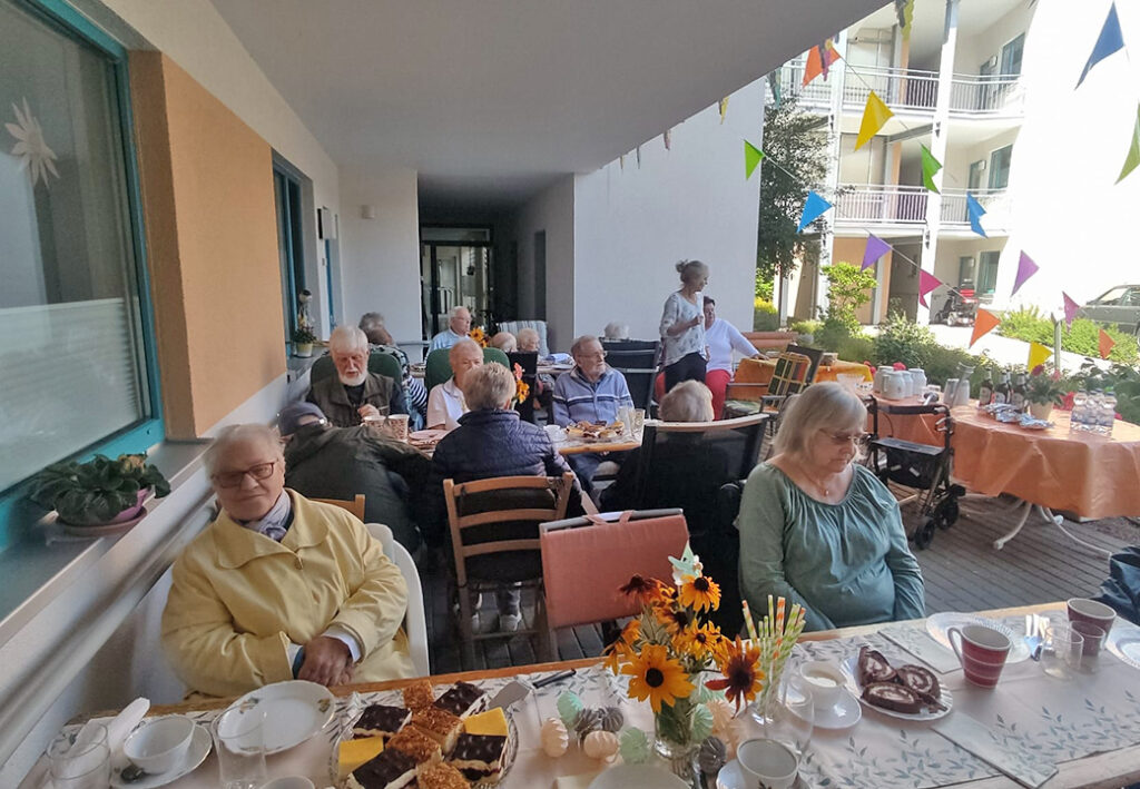 Menschen bei einem geselligen Treffen unter einem Pavillon.