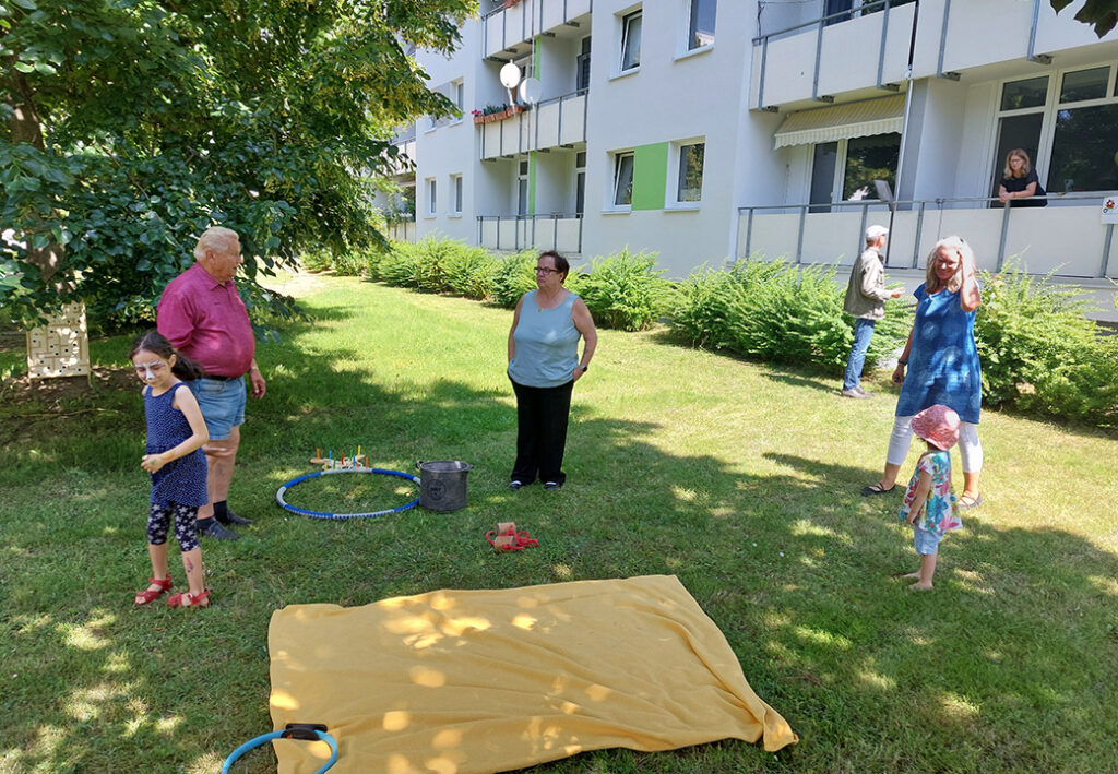 Menschen auf einer Wiese vor einem Gebäude