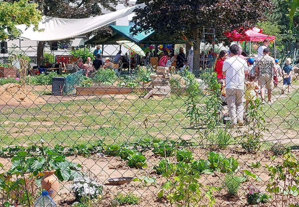 Menschen versammeln sich unter Pavillons in einem Garten f&uuml;r eine Veranstaltung.