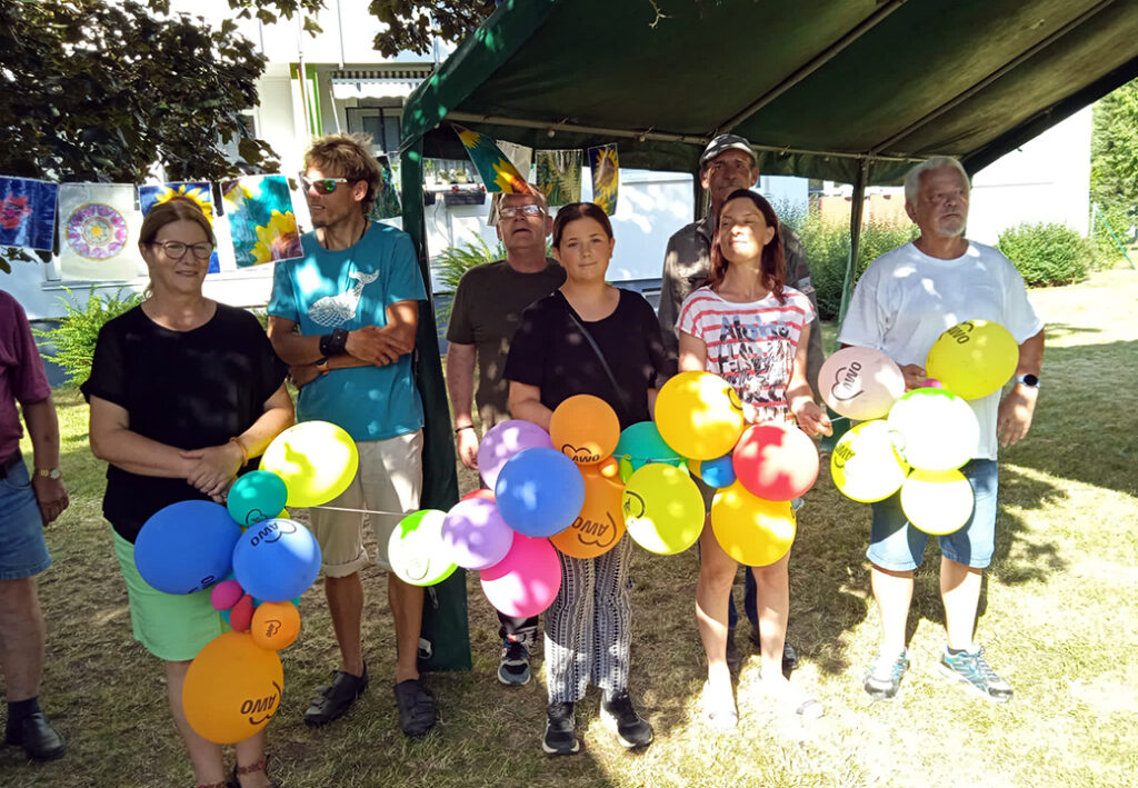 Gruppe von Menschen mit bunten Luftballons im Freien