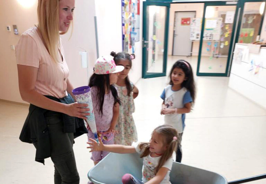 Erwachsene Frau &uuml;berreicht Kindern eine Zuckert&uuml;te