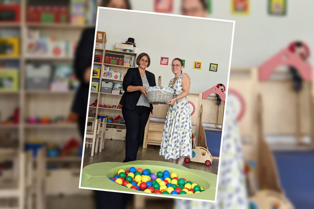 Zwei Frauen in einem Spielzimmer halten zusammen einen Korb.