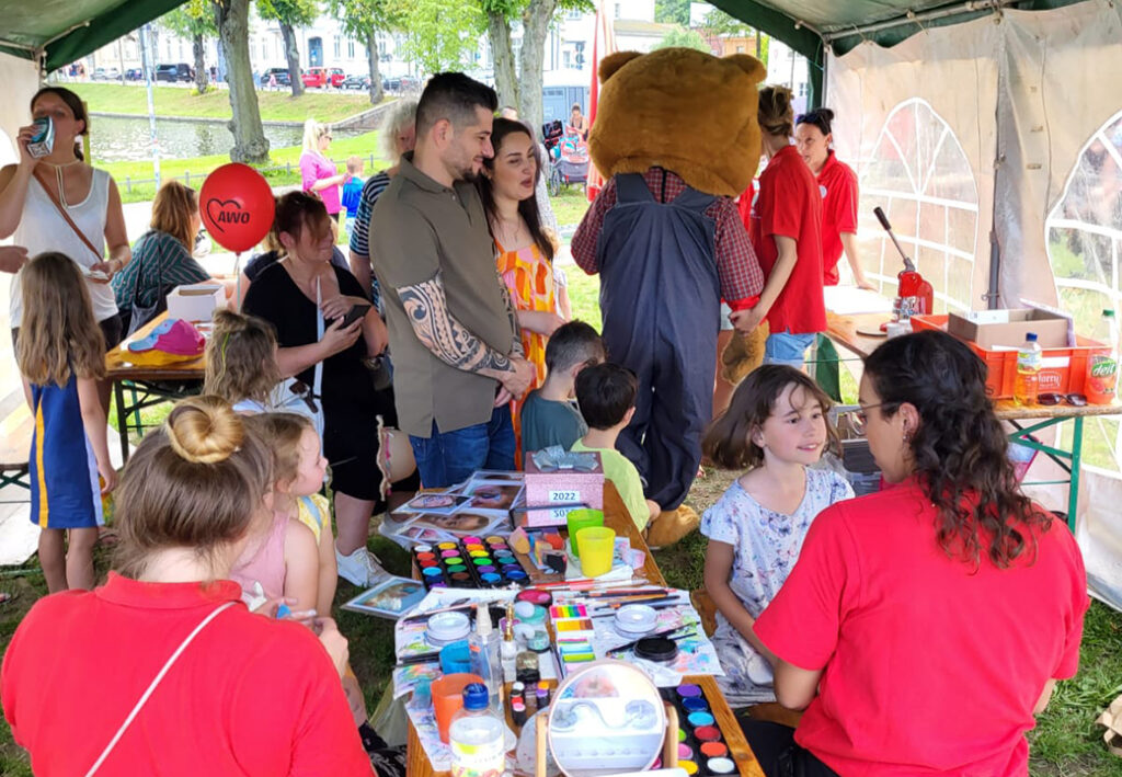 Menschen auf einem AWO-Sommerfest unter einem Zelt