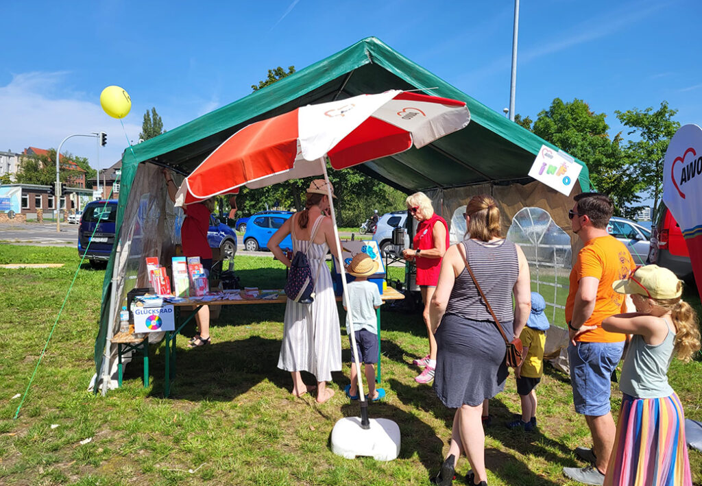 Ein Veranstaltungstent der AWO mit Menschen, die sich umsehen und informieren.