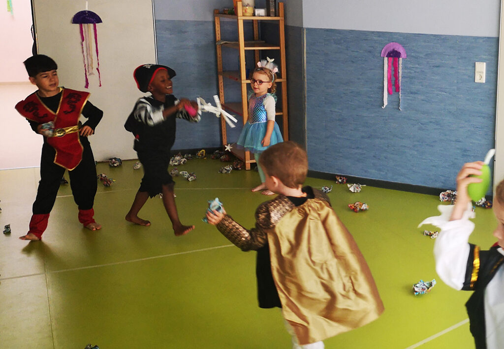 Kinder in Kost&uuml;men spielen in einem Raum