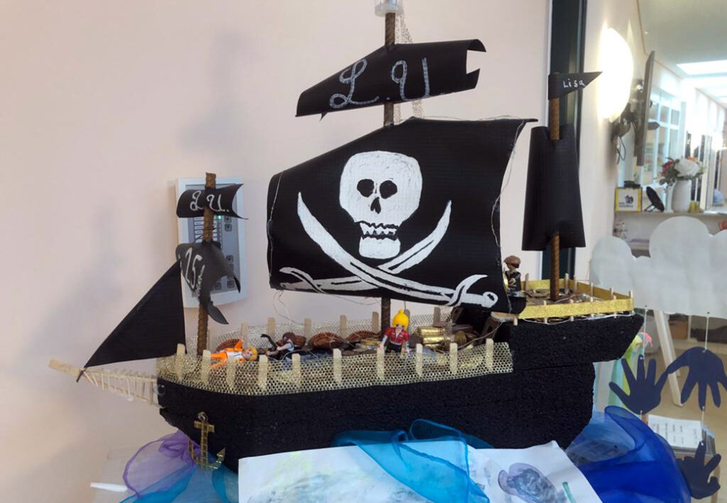 Ein Modell eines Piratenschiffs mit schwarzen Segeln und Playmobil-Piratenfiguren