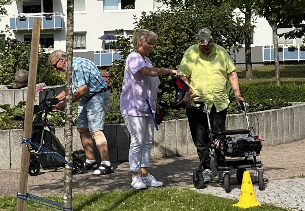 Drei Personen im Freien mit Rollatoren