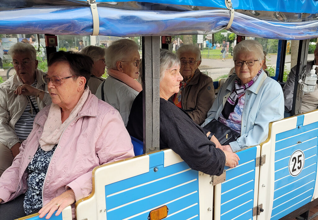 &Auml;ltere Damen sitzen in einer kleinen Bahn f&uuml;r eine Ausflugsfahrt.