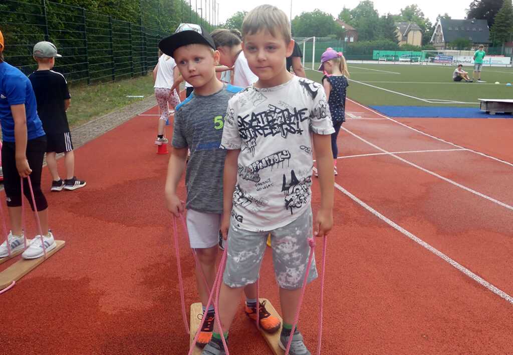 Zwei Kinder auf einem Sportplatz beim Teamspiel