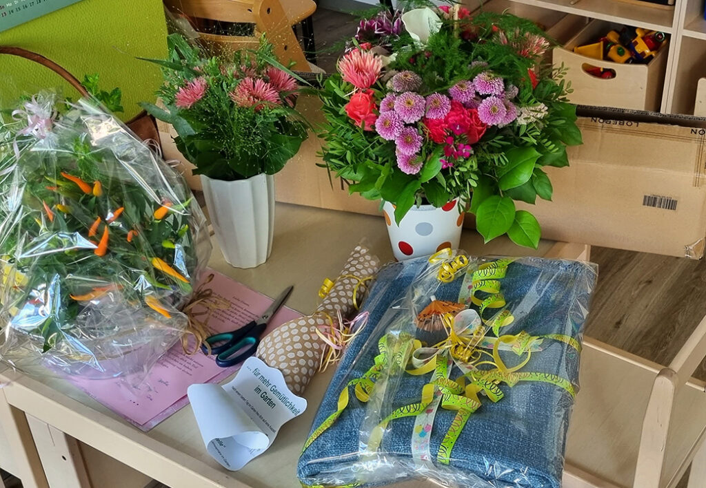 Ein Tisch mit Blumen und Geschenken