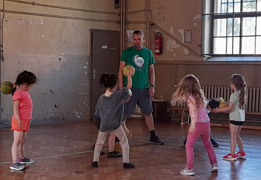 Kinder beim Ballspiel in einer Turnhalle