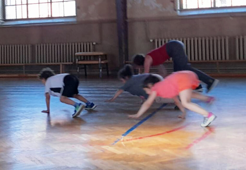 Vier Personen krabbeln auf allen Vieren in einer Halle