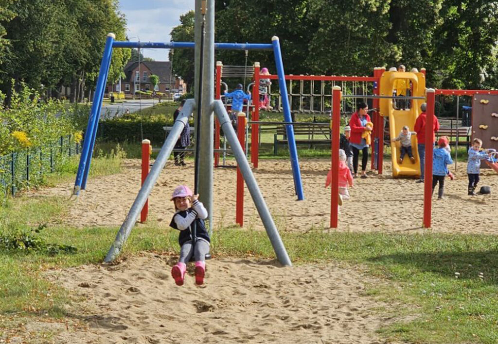 Kinder auf einem Spielplatz mit Kletterger&uuml;sten und Rutsche