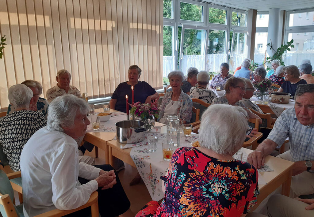 &Auml;ltere Menschen bei einem geselligen Treffen in einem Gemeinschaftsraum