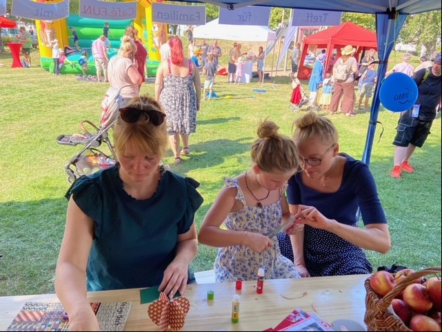 Menschen bei einem Handwerkstisch auf einem Fest