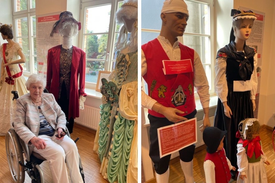 Ältere Frau im Rollstuhl und Schaufensterpuppen in traditioneller Kleidung