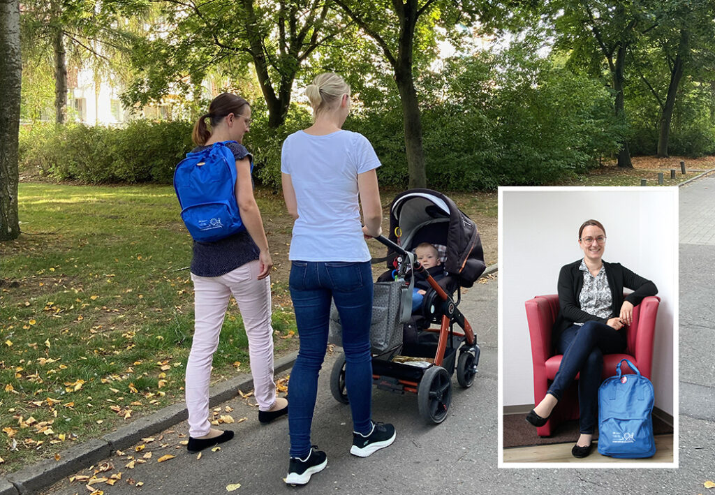 Zwei Frauen gehen mit einem Kind im Kinderwagen im Park spazieren.