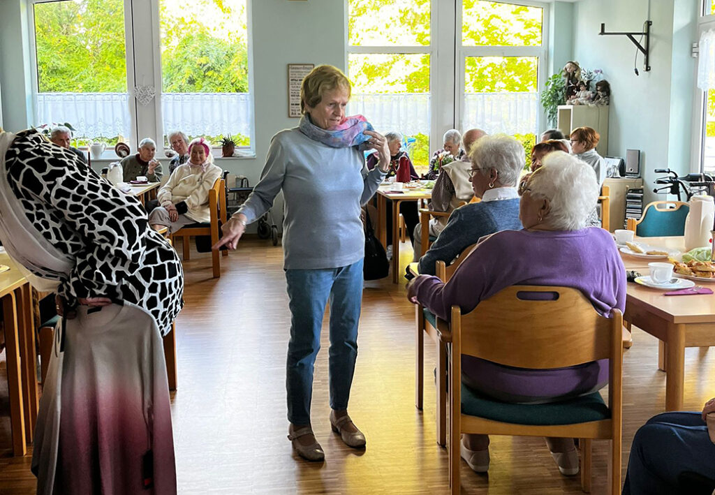 Ältere Menschen sitzen in einem Aufenthaltsraum bei Kaffee und Kuchen