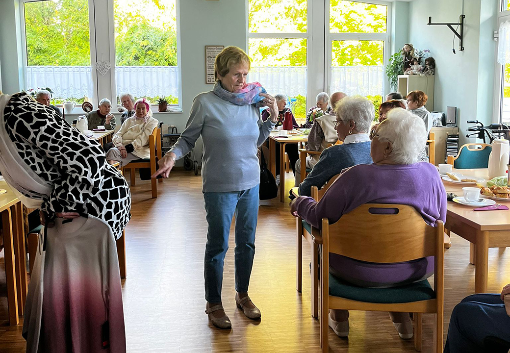 Ältere Menschen sitzen in einem Aufenthaltsraum bei Kaffee und Kuchen