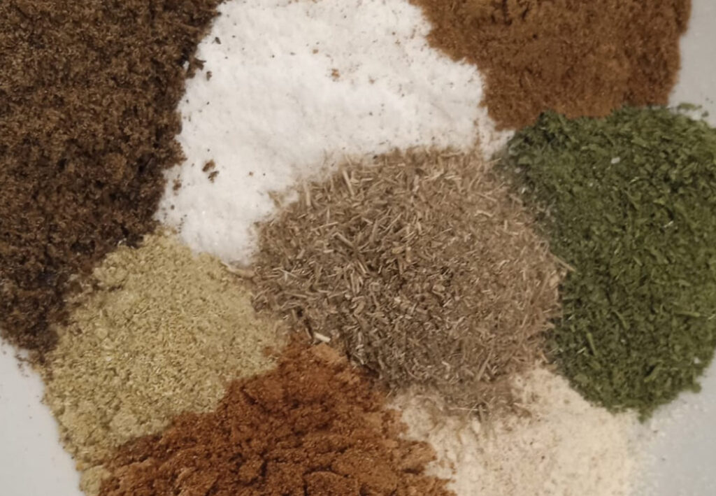 Verschiedene Gew&uuml;rze in kleinen Haufen auf einem Teller