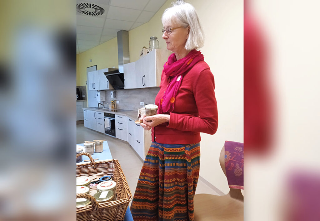 Eine Frau steht in einer K&uuml;che mit einem Korb auf dem Tisch.