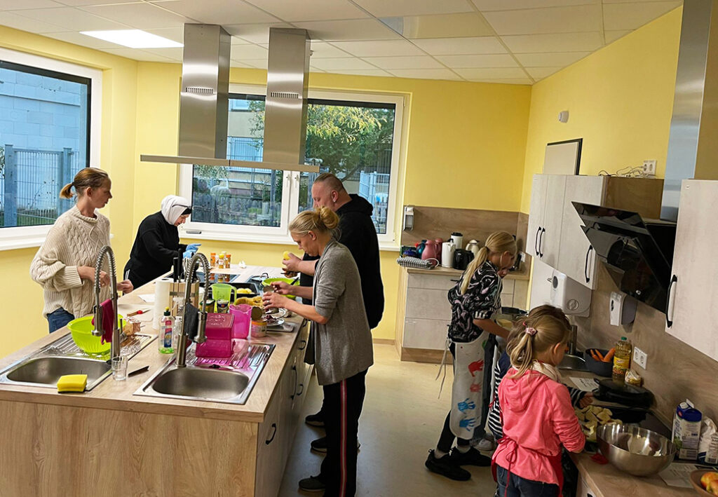 Menschen in einer modernen Gemeinschaftsk&uuml;che beim Kochen