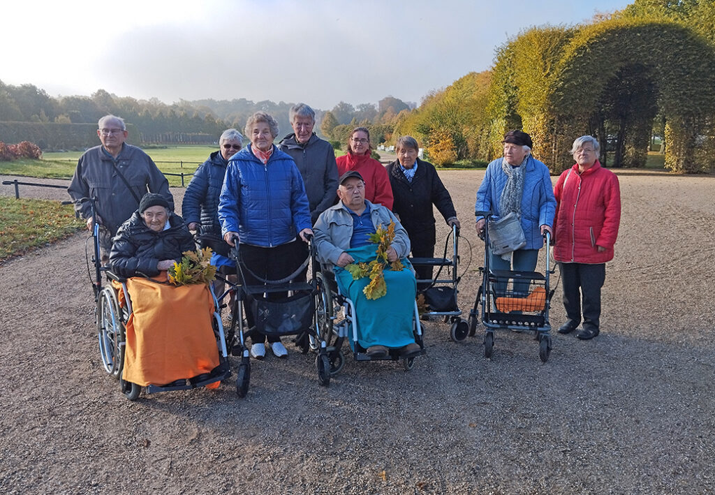 Gruppe von Senioren im Freien mit Rollst&uuml;hlen und Rollatoren