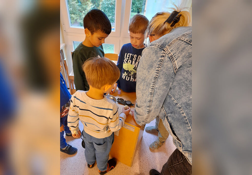 Foto einer Gruppenaktivit&auml;t mit Kindern und einer Betreuerin