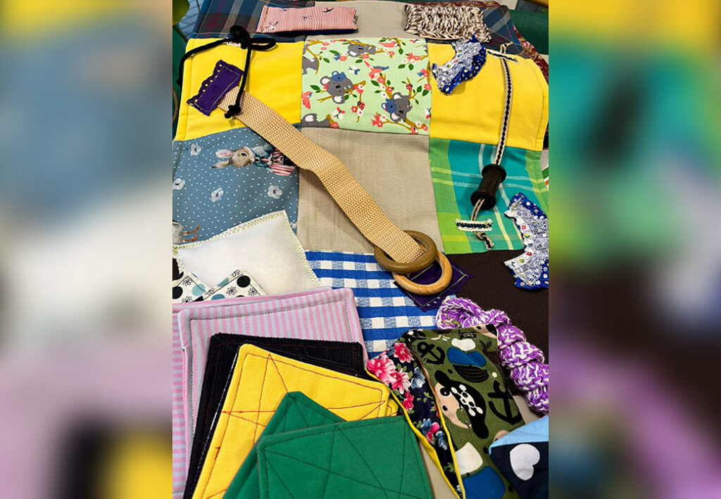 Patchwork-Decke mit verschiedenen Stoffmustern und haptischen Elementen