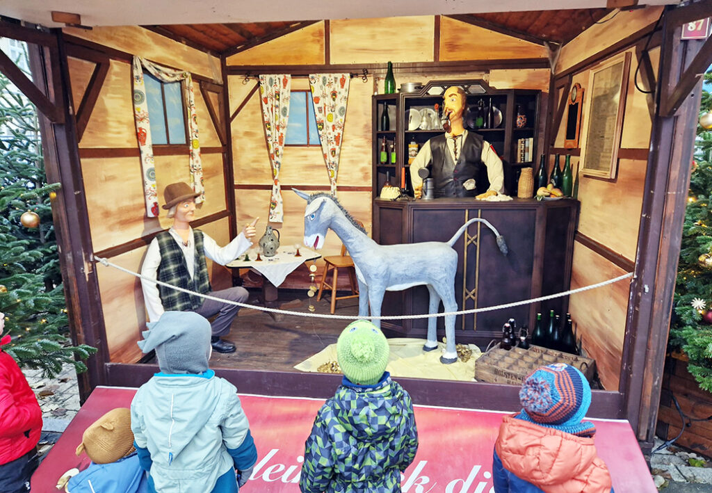 Ein weihnachtlich dekoriertes Schaufenster oder eine Austellungsbox mit Figuren.