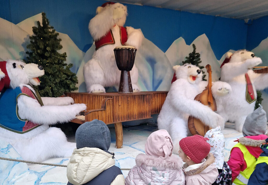 Kinder beobachten animierte Eisb&auml;ren, die Musikinstrumente spielen.