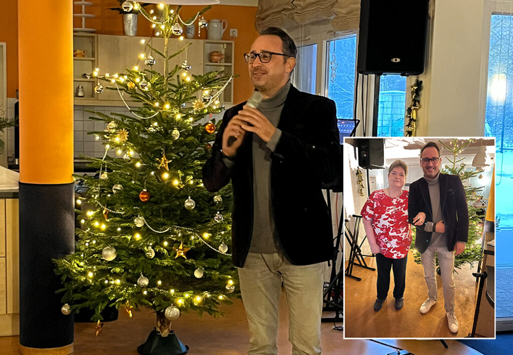 Mann spricht vor einem Weihnachtsbaum