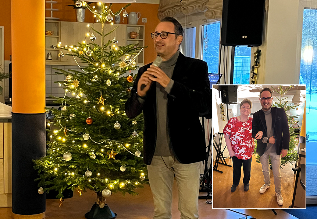 Mann spricht vor einem Weihnachtsbaum