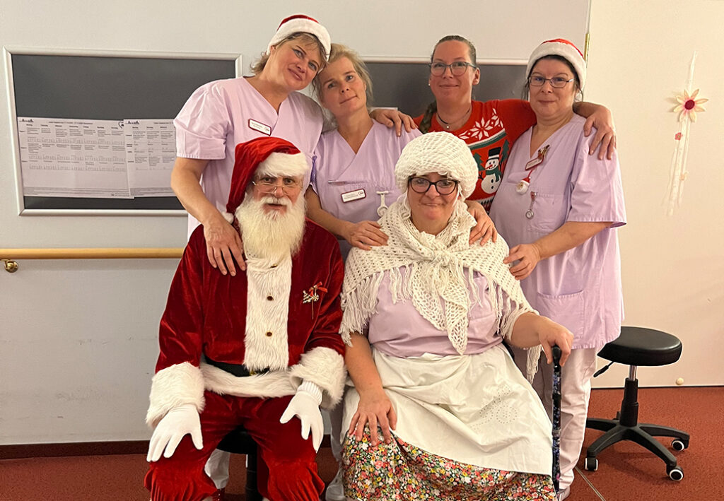 Eine Gruppe von Menschen in Weihnachtskost&uuml;men, zwei sitzend und vier stehend.