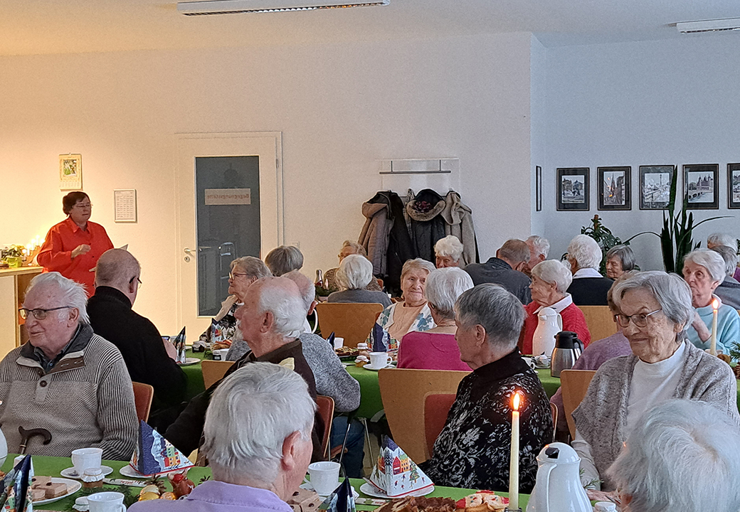 Ältere Menschen bei einem Treffen in einem Gemeinschaftsraum.