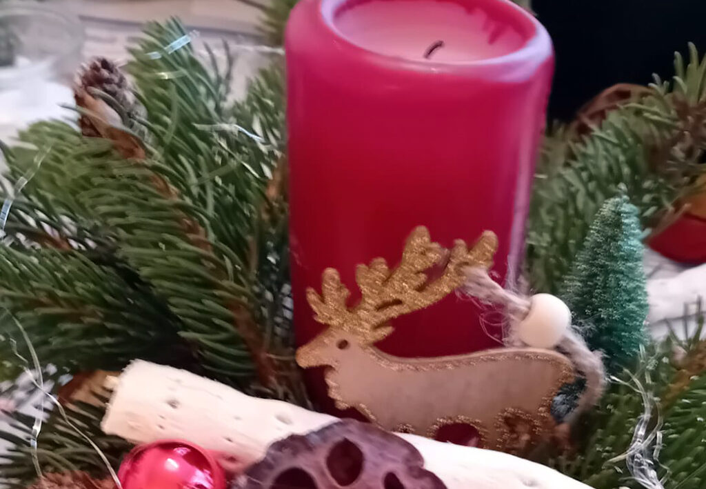 Ein weihnachtliches Arrangement mit einem roten Adventskranz.