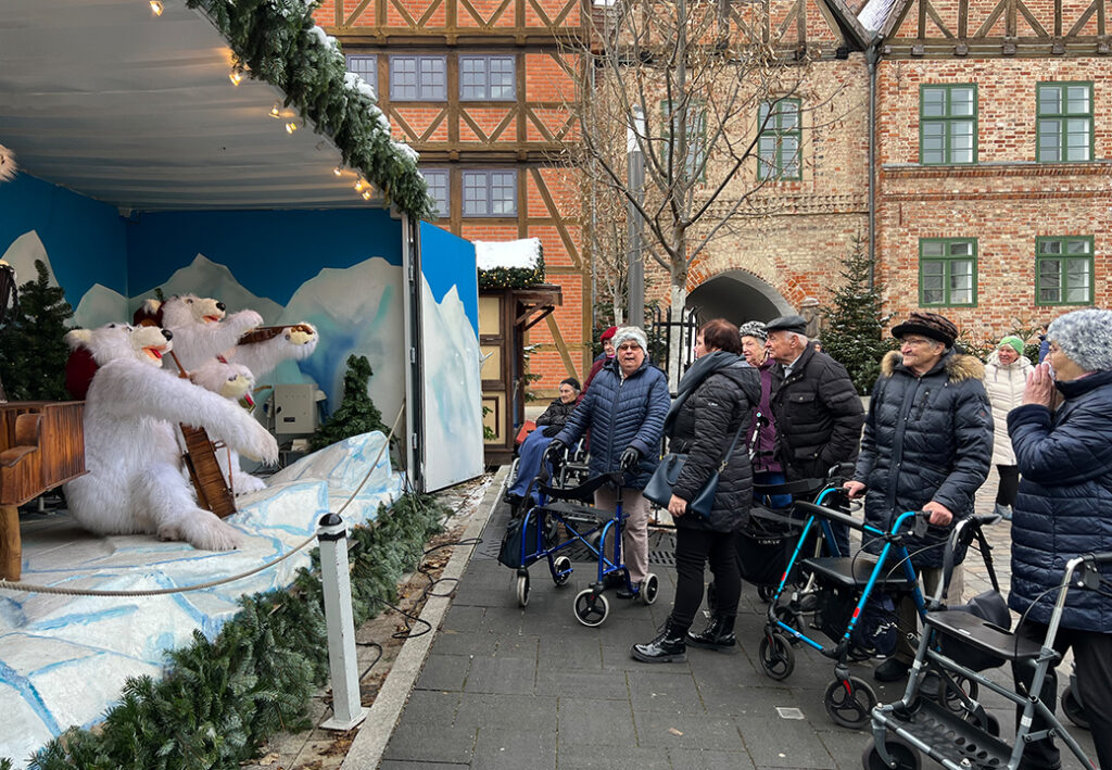 Menschen vor einer Schaufensterausstellung mit Weihnachtsdekor und Pl&uuml;schtieren