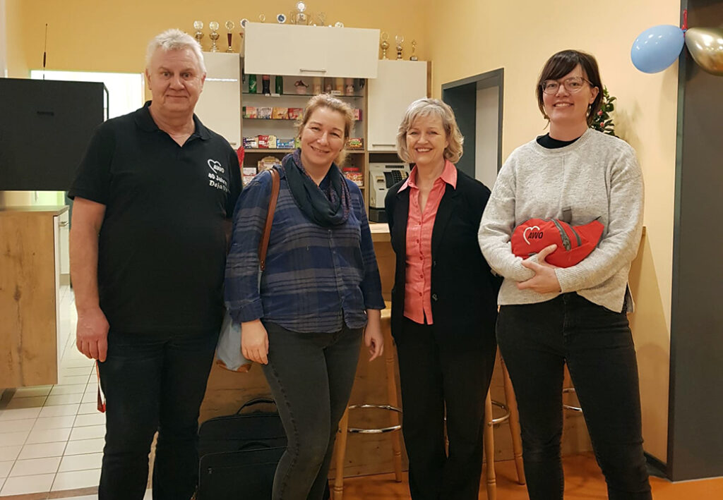 Gruppe von vier Personen in einem Innenraum.