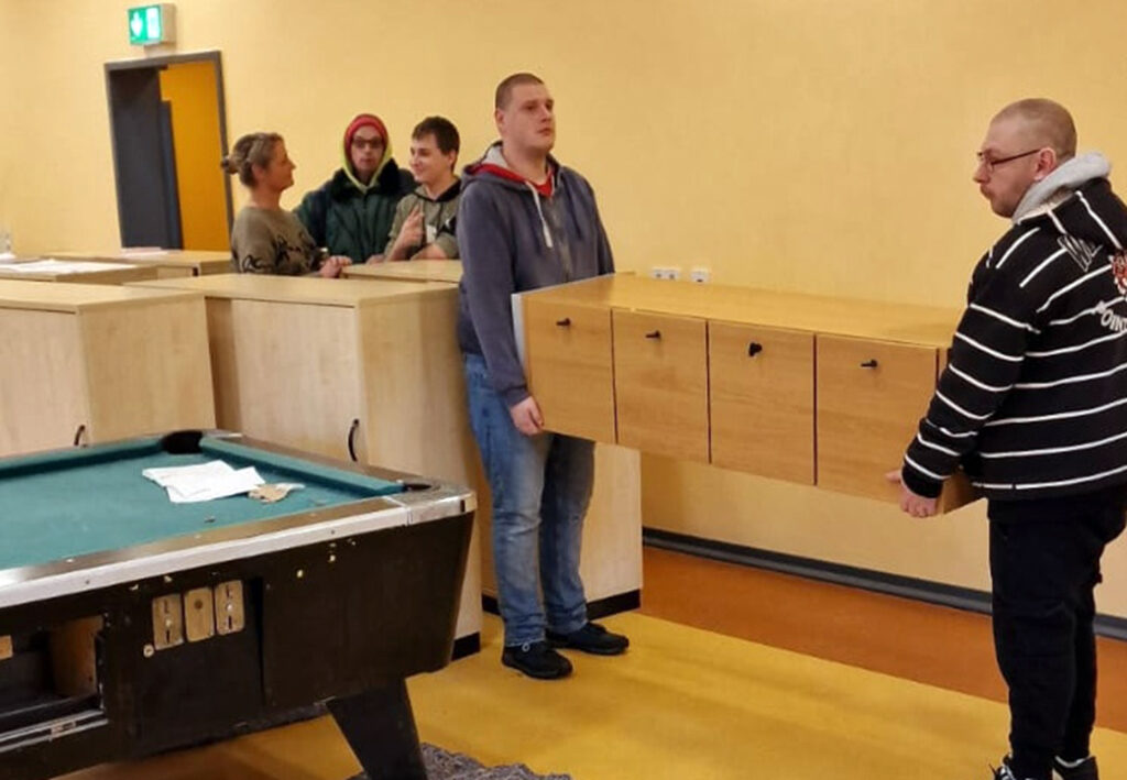 Gruppe von Menschen in einem Raum mit Billardtisch und M&ouml;beln.