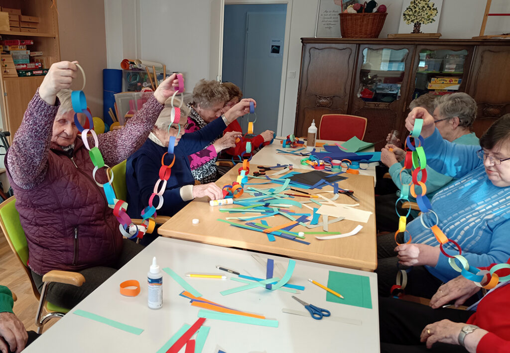 Senioren machen Bastelarbeiten am Tisch