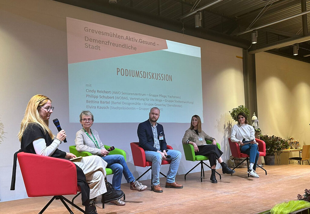 Podiumsdiskussion mit f&uuml;nf Personen auf einer B&uuml;hne
